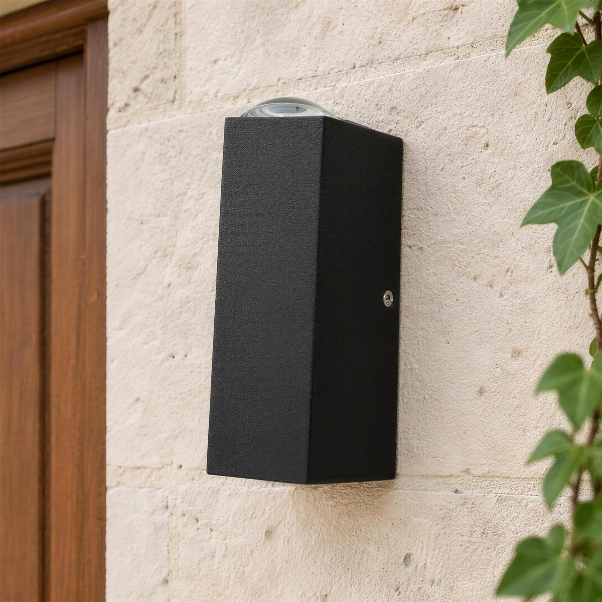 Détail du boîtier en aluminium noir de l'applique extérieure et de son optique supérieure