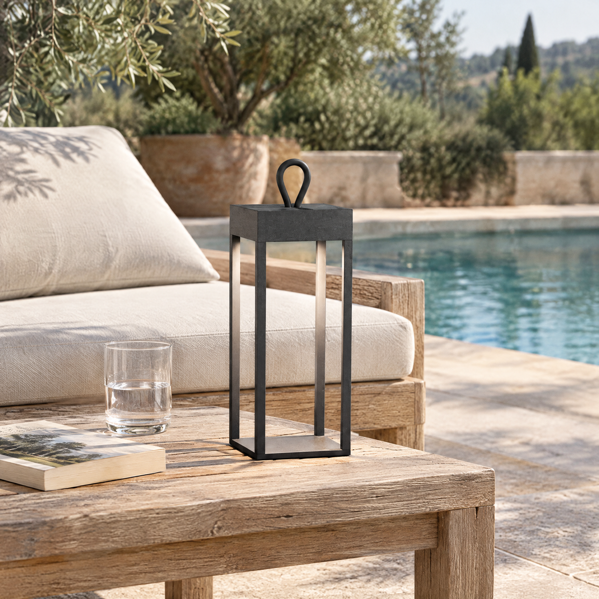 Lanterne LED sans fil anthracite sur une table basse en teck au bord d'une piscine
