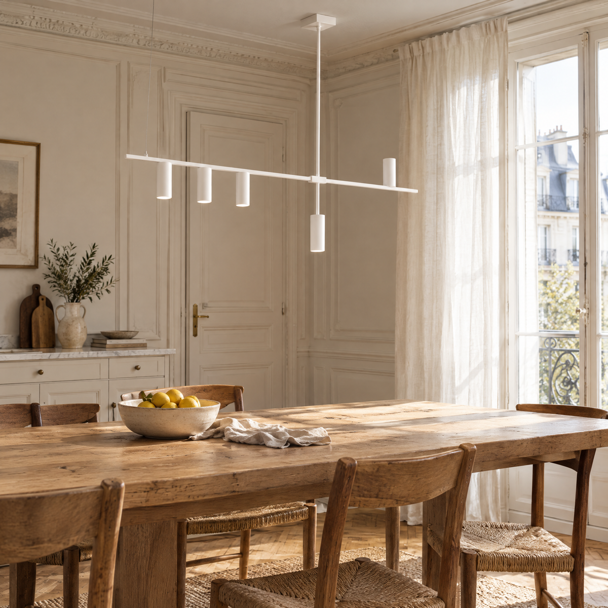 Suspension linéaire blanche au-dessus d'une table de cuisine en chêne, en journée