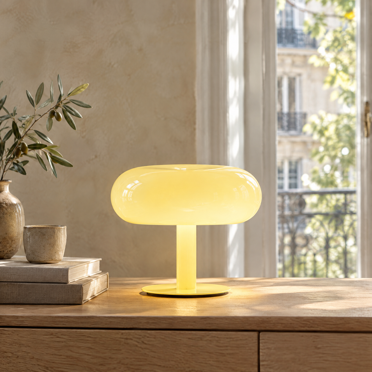Lampe champignon jaune pastel allumée sur une console en chêne