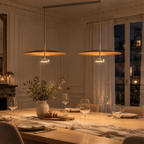 Double suspension disque effet noyer allumée au-dessus d'une table de salle à manger, le soir
