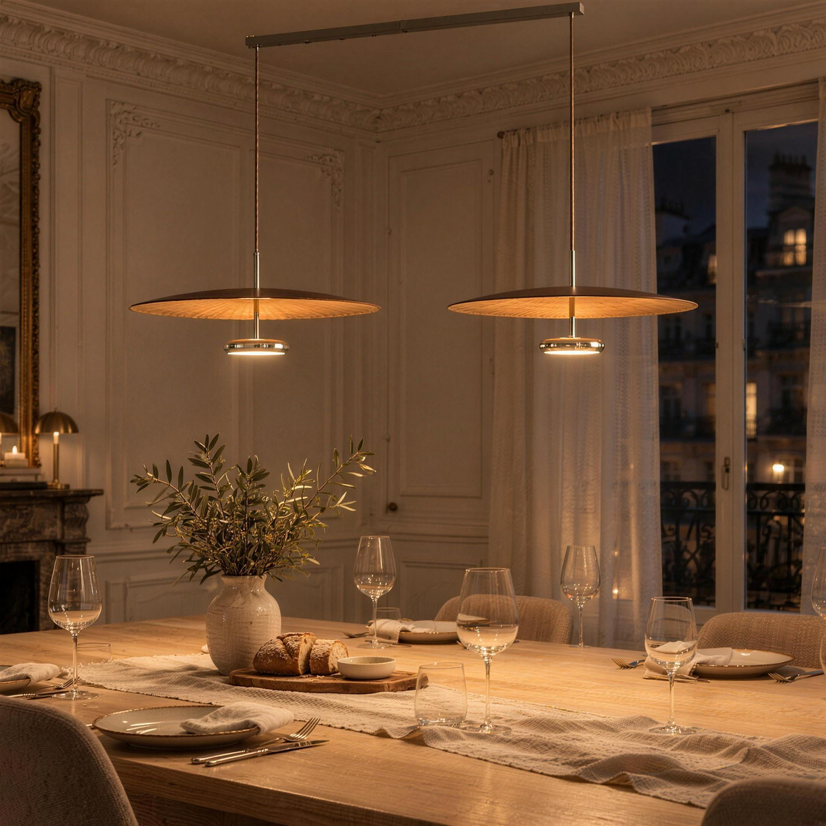 Double suspension disque effet noyer allumée au-dessus d'une table de salle à manger, le soir