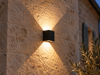 Faisceaux lumineux de l'applique cube noire sur un mur en pierre calcaire