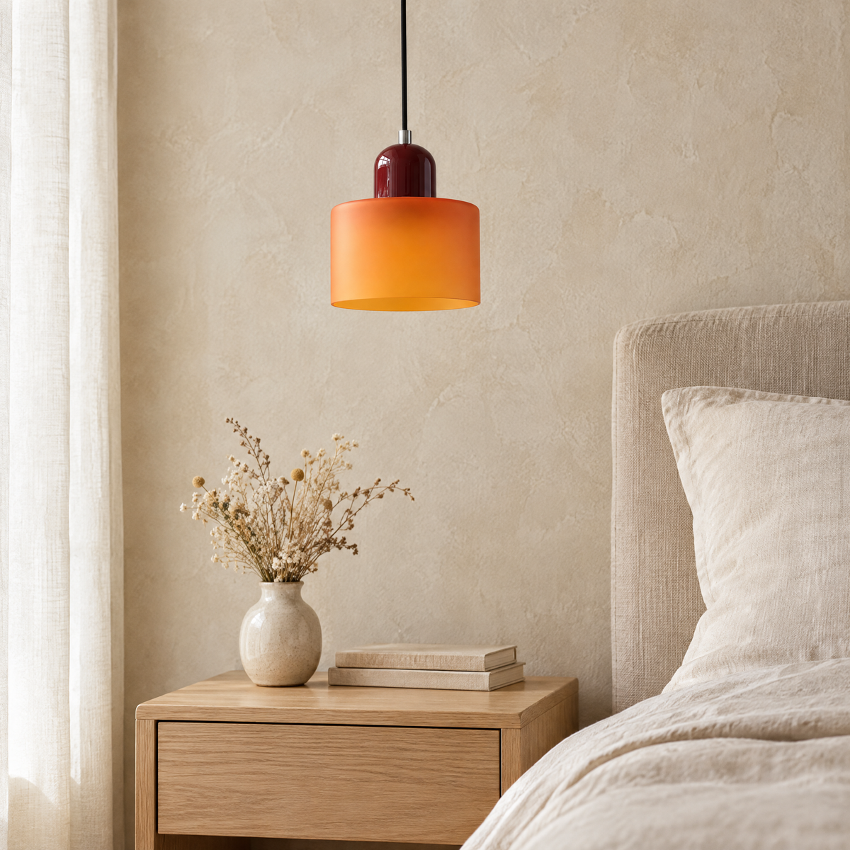 Suspension verre orange, chapeau bordeaux, au-dessus d'une table de chevet