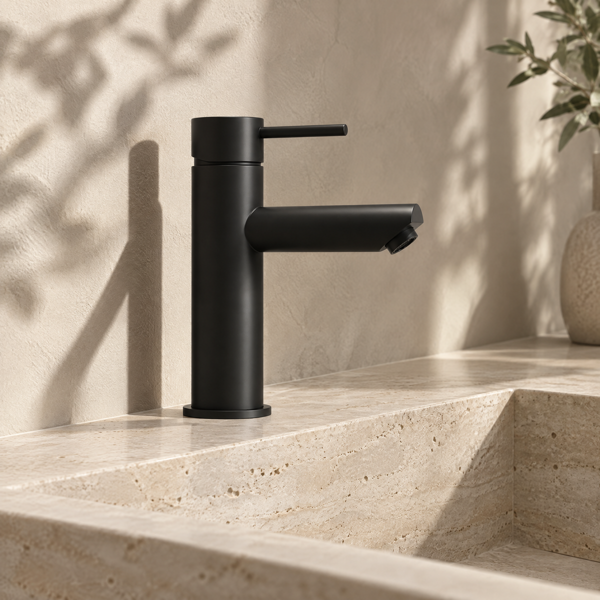 Mitigeur lavabo monotrou noir mat sur un lavabo en travertin