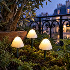 Champignons solaires LED allumés dans une jardinière sur une terrasse