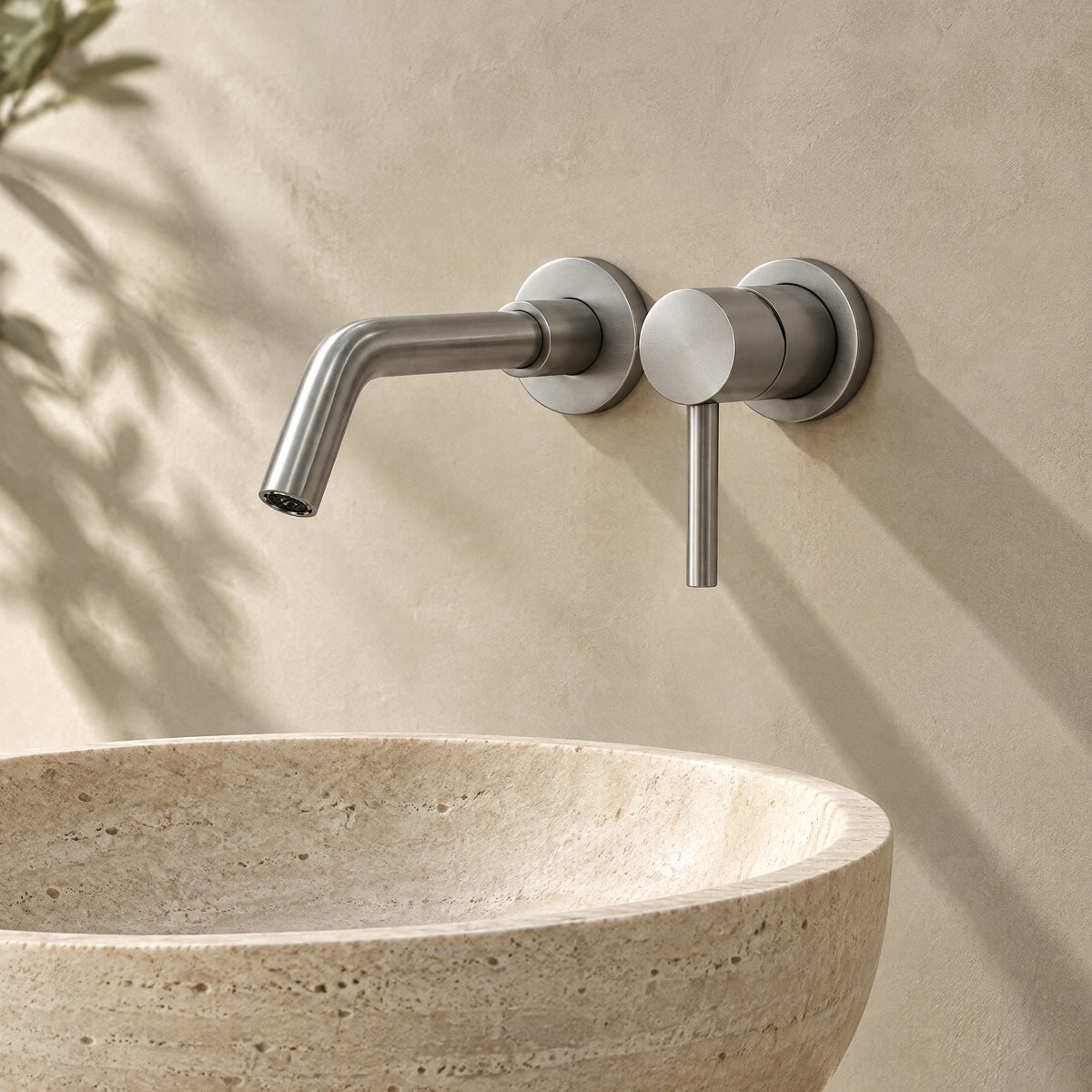 Mitigeur lavabo mural encastré nickel brossé au-dessus d'une vasque en travertin