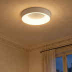 Plafonnier LED rond blanc allumé au plafond d'une chambre haussmannienne