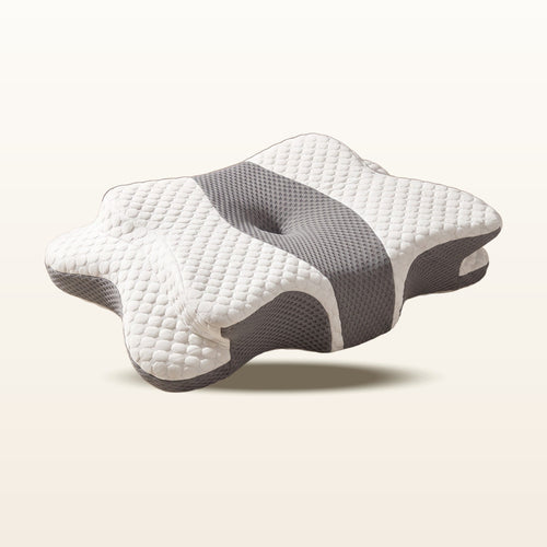 Oreiller cervical ergonomique papillon Maison Reposéa, mousse haute densité, housse blanche et panneau de maille grise, sur fond crème