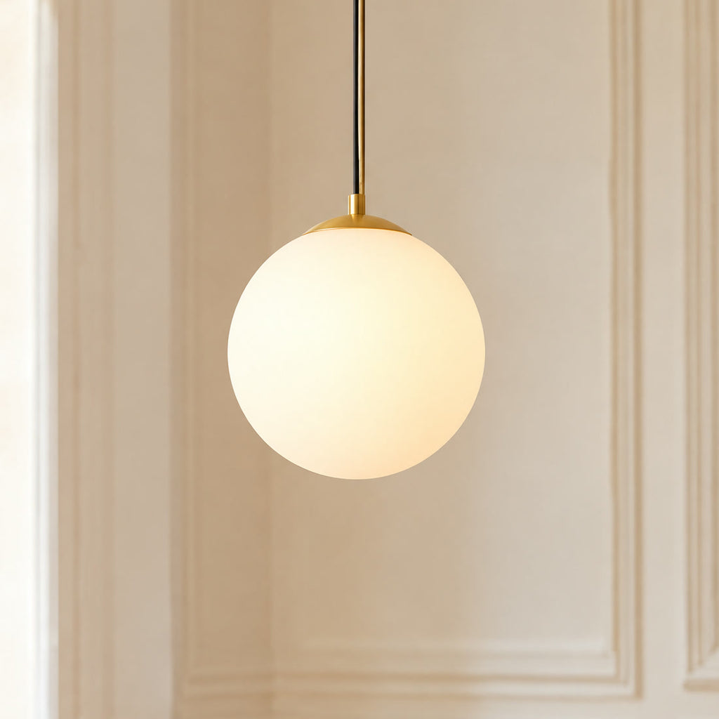 Suspension boule en verre opaline blanche allumée, pavillon doré, en gros plan